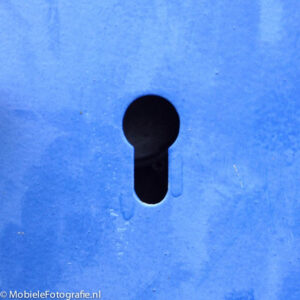 Sleutelgat in een blauwe metalen kast gefotografeerd met een iPhone 4s
