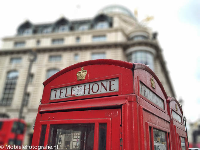 iPhone6 foto van telefooncel in Londen. Het gebouw erachter is vervaagd in AfterFocus.