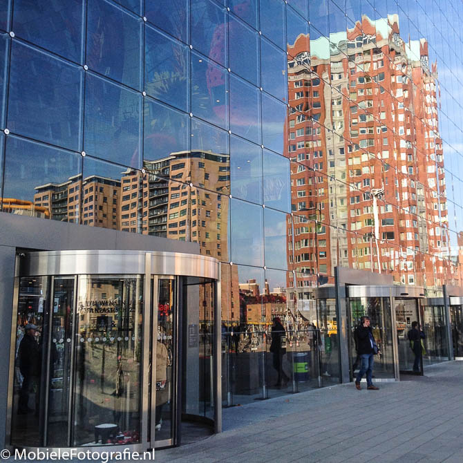Foto van de glazen gevel van de Martkhal in Rotterdam die de omgeving reflecteert. [iPhone 6]
