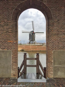 Foto van een omlijsting van een molen door een vestingmuur in Heusden. [iPhone 6]