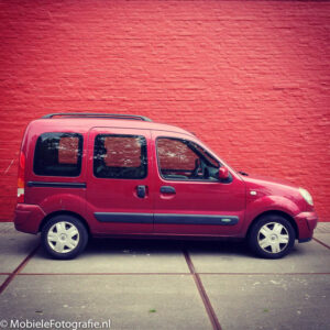 Voorbeeldfoto van Monochromatische kleuren: een rode auto voor een rode muur. [iPhone 4s]