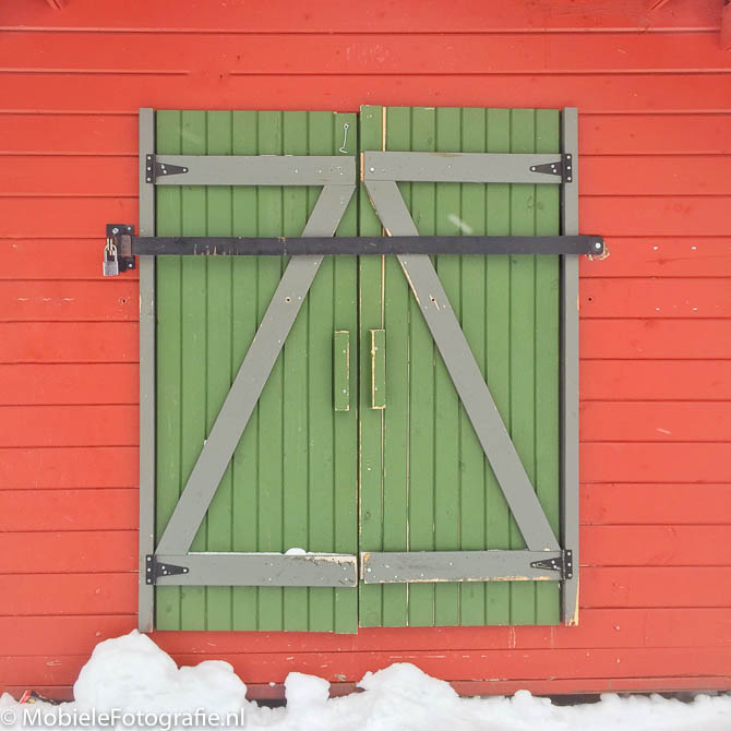 Voorbeeldfoto van Complementaire kleuren: een groene deur in een rode muur. [iPhone 6]